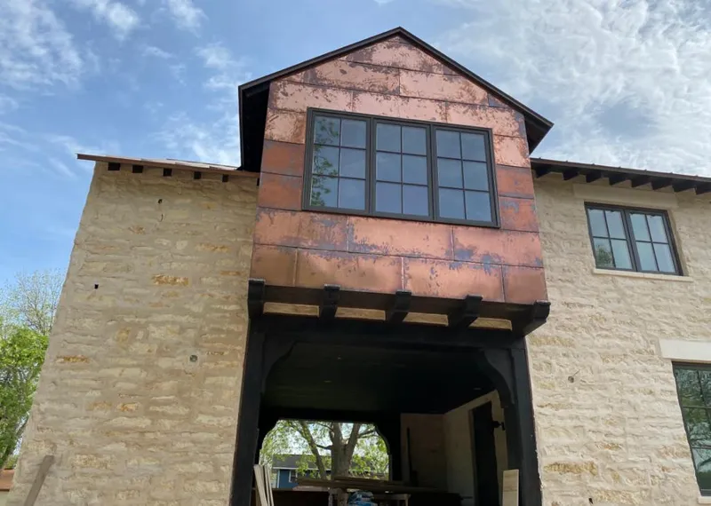 Copper metal panel facade on a stone building for Roof Repair in Woodbury